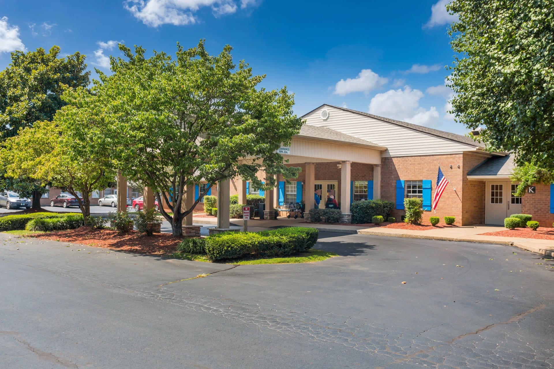Exterior of main lobby with entrance covered by large canopy and surrounded by trees and landscaping Image Gallery | Exterior of main lobby with entrance covered by large canopy and surrounded by trees and landscaping